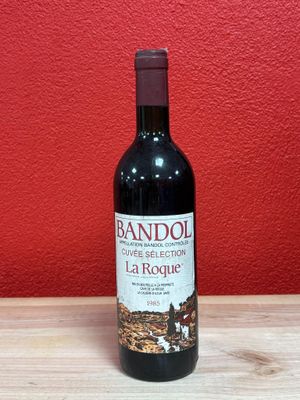 the bottle of red wine is sitting on a wooden table