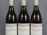 trois bouteilles de vin sont alignées sur une table