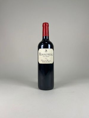 a bottle of red wine sitting on top of a white table