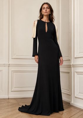 une femme en robe noire, debout dans une pièce