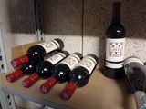 several bottles of wine are lined up on a shelf in a wine cellar