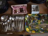 a lot of silverware on a table with plates and spoons