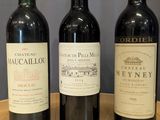 three bottles of wine are lined up on a wooden table