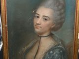 un vieux tableau représentant une femme en robe bleue, posé sur un chevalet