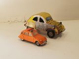 a toy car and a toy car on a white surface