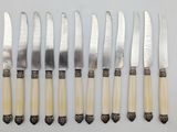 six knives and six knives are lined up on a white surface