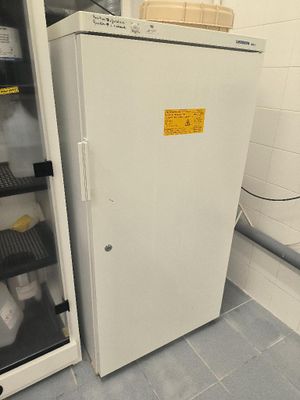 a refrigerator that is sitting in a room with a lot of bottles