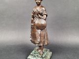 bronze statue of a woman holding a ball on a marble base