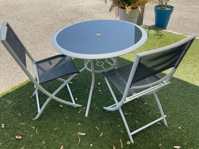 deux chaises et une table sur l'herbe