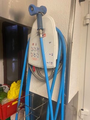un tuyau bleu fixé à un mur blanc