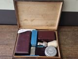 a wooden box with a watch, a book, and other items in it