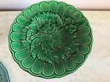 a green plate with a flower on it next to a cookie cutter