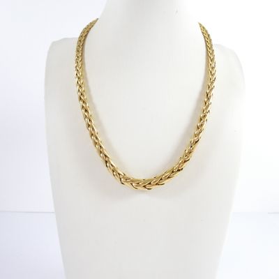 a close up of a gold necklace on a mannequin mannequin