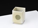 a white cup with a hole in it on a table
