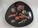 a black plate with a picture of lobsters and shells on it