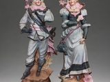 pair of porcelain figurines of two women dressed in period clothing