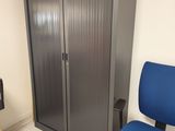 a blue chair in front of a metal cabinet