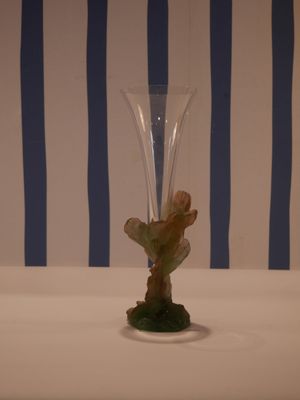 a glass vase with a flower in it sitting on a table