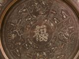 a brown plate with designs on it on a table