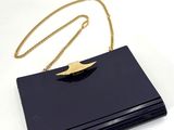 une pochette noire ornée d'une chaîne dorée sur le dessus