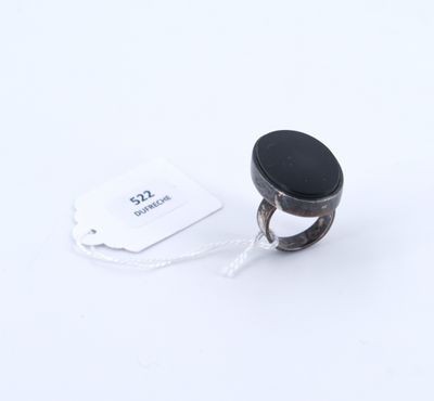 une image représentant une bague sertie d'une pierre noire sur fond blanc