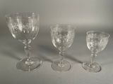 three empty wine glasses sitting on a table next to each other