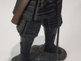 figurine of a man in armor holding a sword and a shield