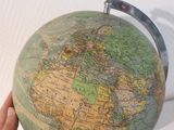 a person holding a small globe in their hand