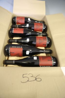six bottles of red wine in a cardboard box on a table