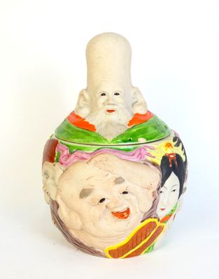 Pot en céramique à décor circulaire de visages en bas relief…