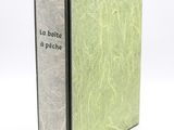 un vieux livre à la couverture verte posé sur une table blanche