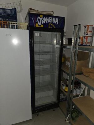a refrigerator that is sitting in a room with shelves