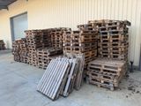 Plusieurs palettes de bois sont empilées devant un bâtiment