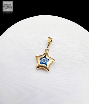 a close up of a gold star pendant on a white surface