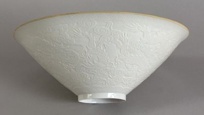 an image of a white bowl with a gold rim on a gray surface