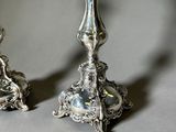 two silver candlesticks that are sitting on a table