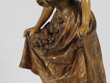 figurine en bronze représentant une femme coiffée d'un chapeau et tenant un panier de fleurs