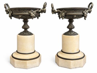 paire de vases anciens en bronze posés sur des socles en marbre, sur fond blanc
