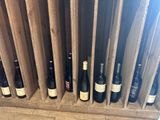several bottles of wine are lined up in a wooden wine rack