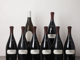 six bouteilles de vin sont alignées sur une table en bois