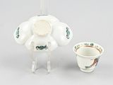 a tea pot and a cup sitting on a table
