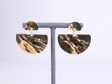 a close up of a pair of earrings on a stand