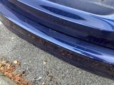 a close up of the front bumper of a blue car