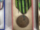 three medals and a medal in a box on a white surface