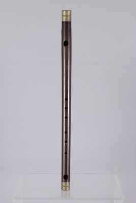 a wooden flute on a clear acrylic stand on a white background