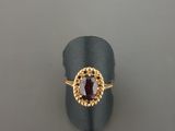 Gros plan sur une bague contenant une pierre rouge