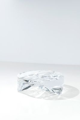 un gros plan d'un objet en verre posé sur une surface blanche