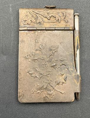 a small silver cigarette case with a pen on it