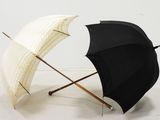 deux parapluies noirs et blancs posés l'un à côté de l'autre sur un sol blanc