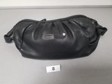 a close up of a black purse on a table with a price tag